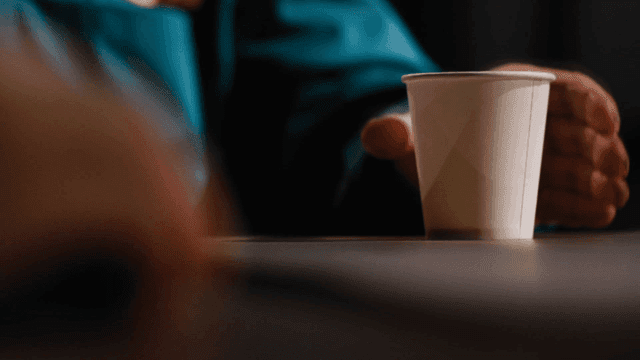 Prisoner putting down paper cup