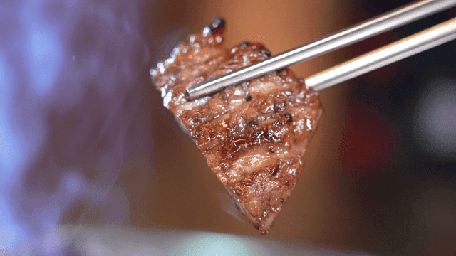 Grilled meat held with chopsticks