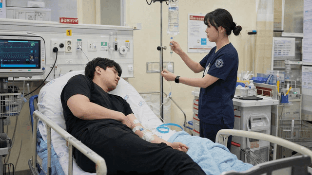 Nurse administering IV fluids to emergency patient at hospital