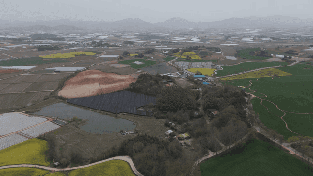 Large farmland with greenhouse.
