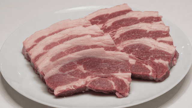 Slices of raw pork belly on a plate