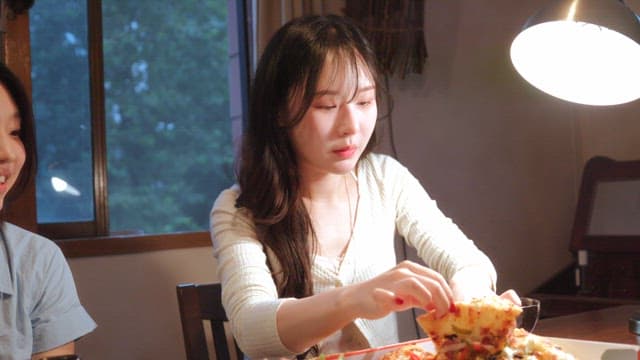 Two women enjoying pizza indoors