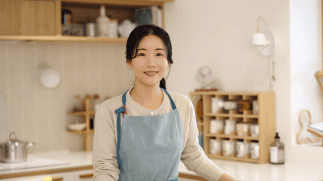 A woman smiling in a cozy kitchen