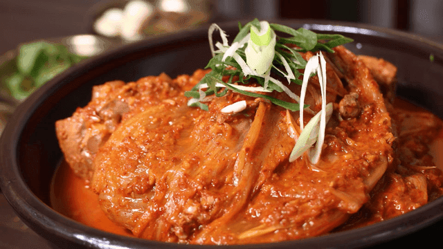 Spicy kimchi stew garnished with toppings