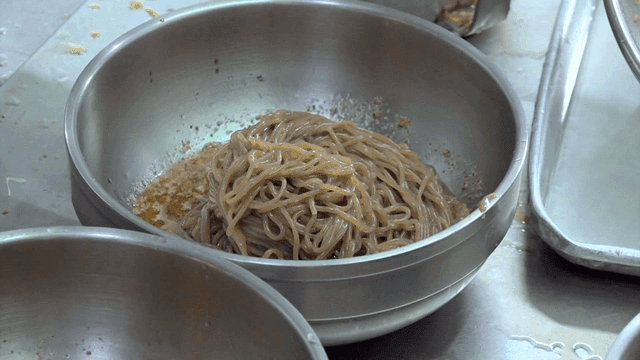 Shiny perilla-oil makguksu served in metal bowl