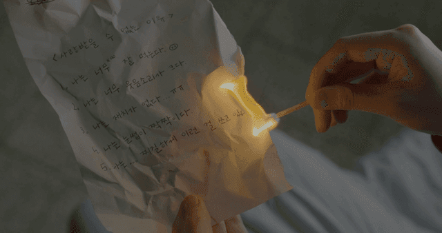 손으로 쓴 메모를 태우는 사람