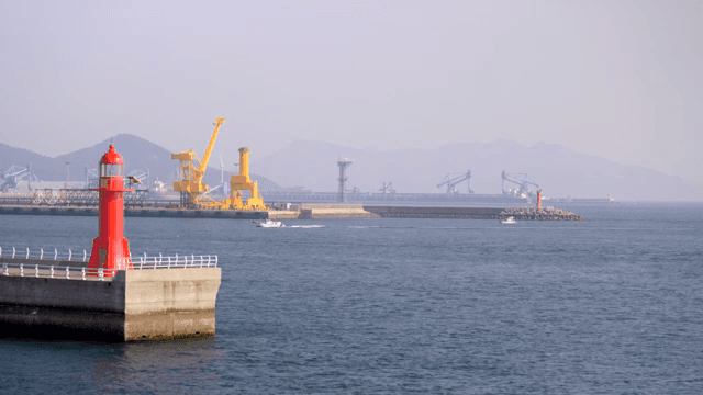 Calm sea with cranes and red lighthouses