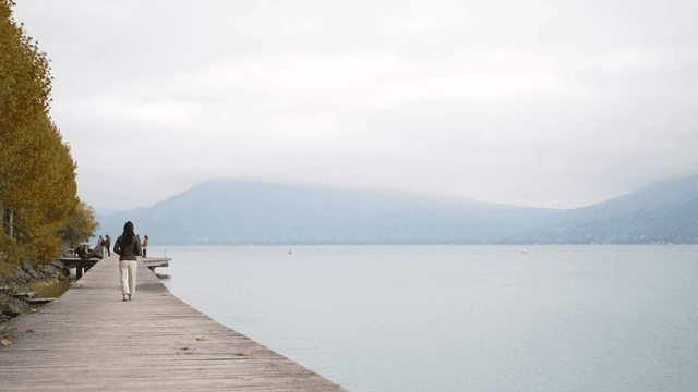 Woman walking along lakeside promenade