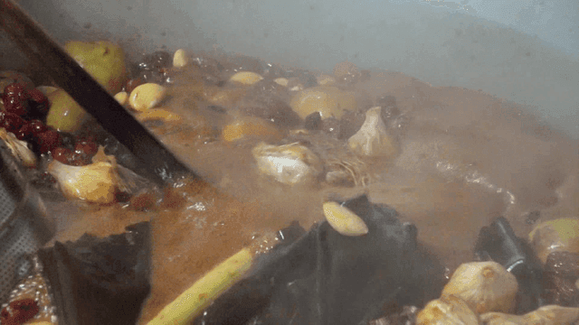 Herbal ingredients boiling in a large pot