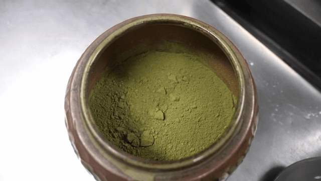 녹차 가루가 담긴 항아리를 여는 모습