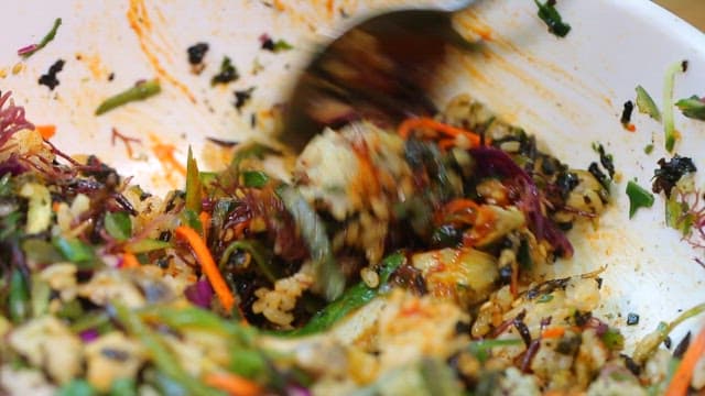 그릇에서 숟가락으로 비빔밥을 섞는 장면