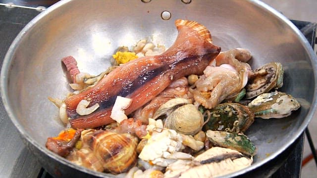 Various seafood such as octopus and abalone in a pan
