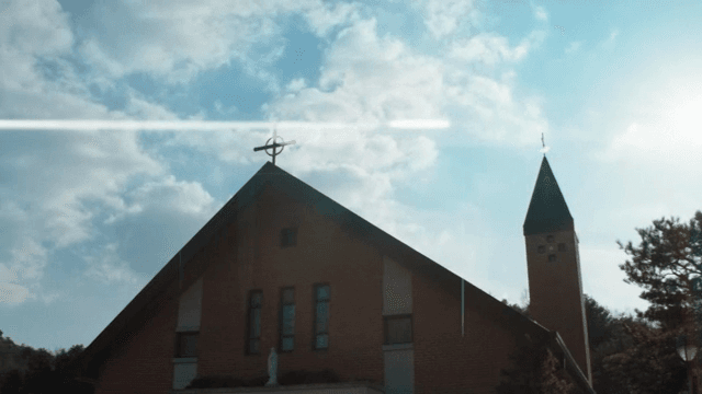 밝은 하늘 아래 십자가가 있는 교회