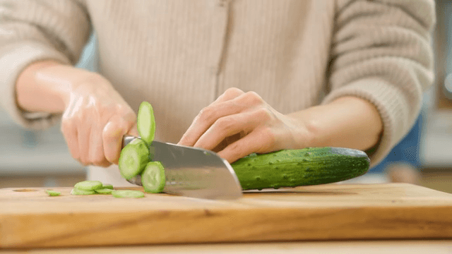 도마 위에서 신선한 오이를 자르는 모습