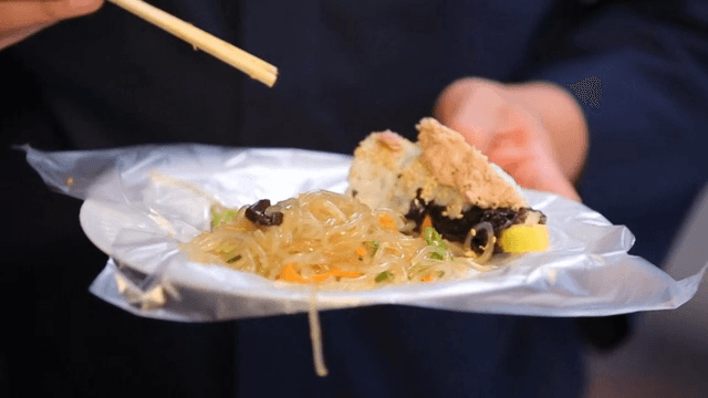 흰 접시 위에 올려진 참치 김밥과 잡채