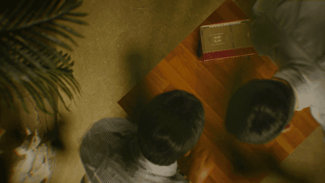 Two people shaking hands at table