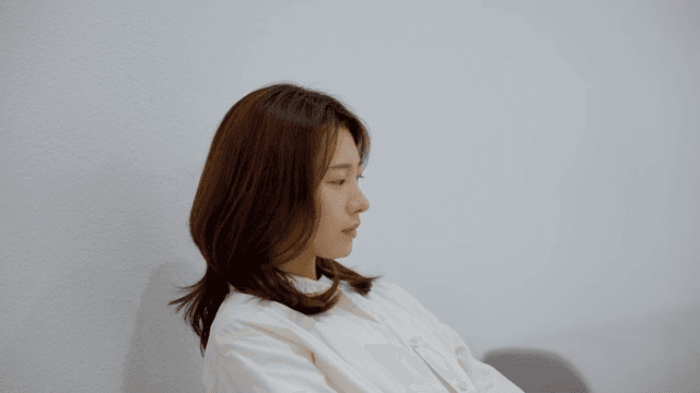 소파에 앉아 초조하게 무언가를 기다리는 여성