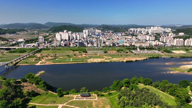 Cityscape with a tranquil river and lush greenery