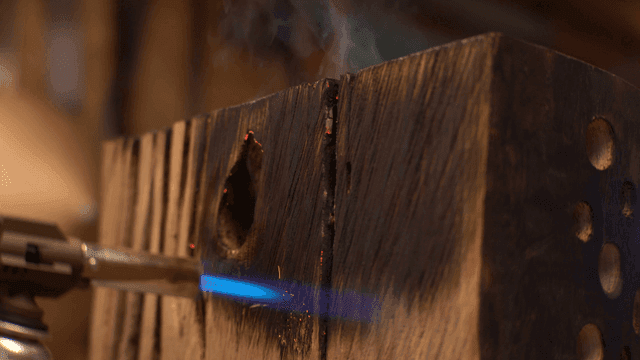 나무 조각품의 표면을 검게 태우는 토치