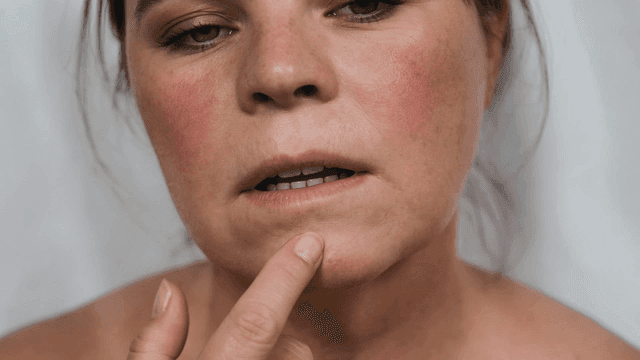 Woman closely examining her skin