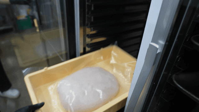 Dough going into proofing machine in kitchen