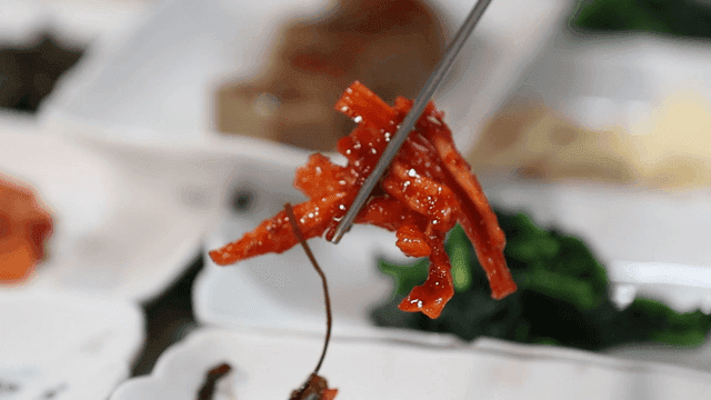 Chopsticks holding spicy Korean radish