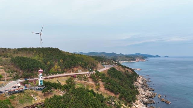 Coastal landscape with wind turbine and lighthouse