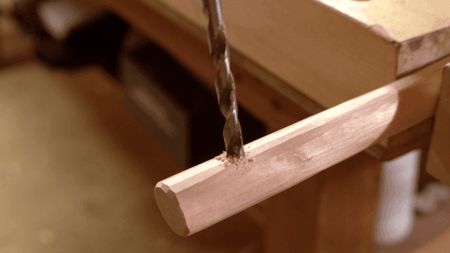 나무 조각에 구멍을 뚫는 장면