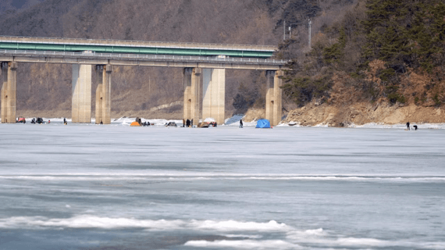 다리 아래에서 얼음 낚시하는 사람들