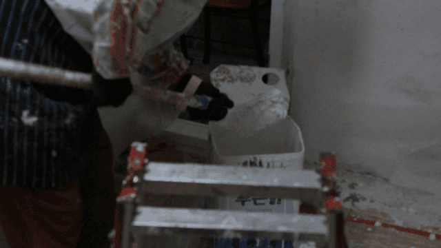 롤러에 페인트를 묻히는 사람