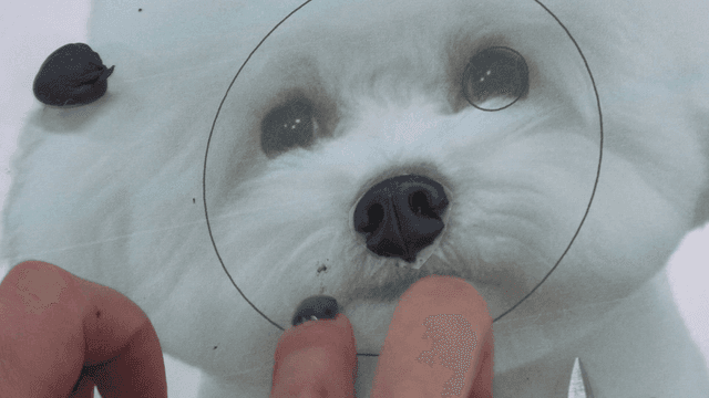 Hands making puppy nose out of clay