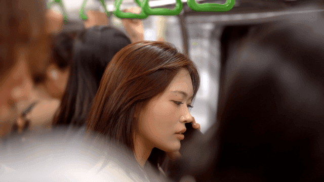 Woman talking on phone in crowded subway