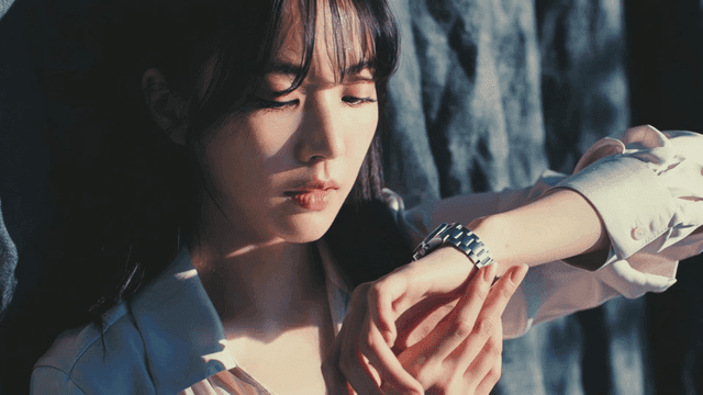 햇빛 속에서 시계를 보는 젊은 여성