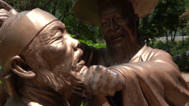 역동적인 포즈를 취한 두 사람의 조각상