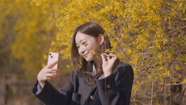 Woman taking a selfie with forsythia