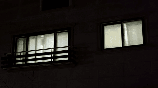 밤에 불이 켜진 창문이 있는 주택