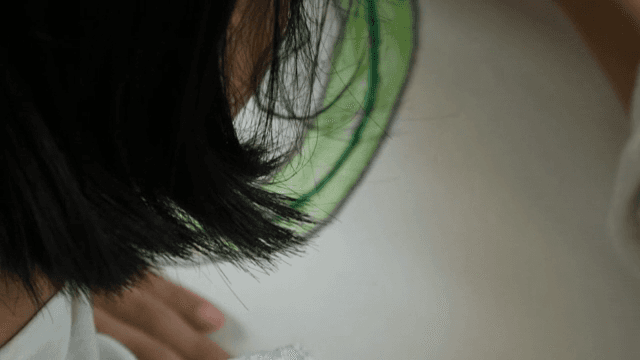 초록색 색연필로 그림을 그리는 사람