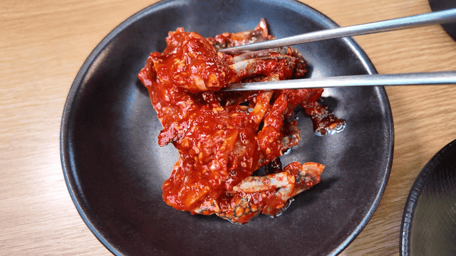 Spicy seasoned crab picked up with chopsticks