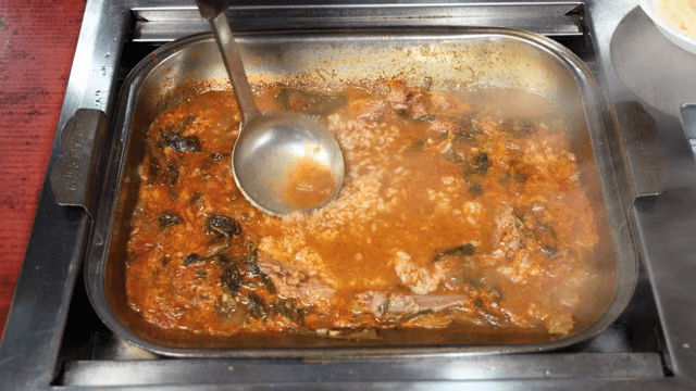 Rice being poured to lamb hot pot