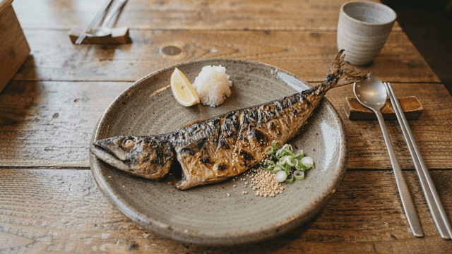 Grilled mackerel served with lemon and garnish