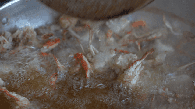 Crabs fried in a pot with steam rising