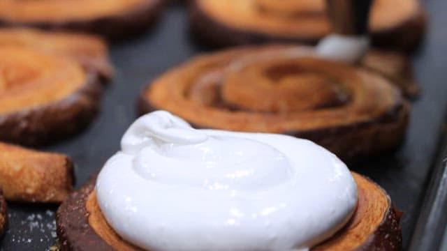 갓 구운 페이스트리 위에 올라가는 하얀 크림