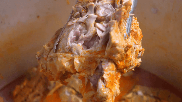 Tender pork backbone stew meat that crumbles with tongs in pot