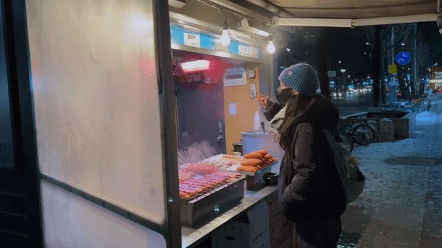 밤에 길거리 음식을 사는 여성
