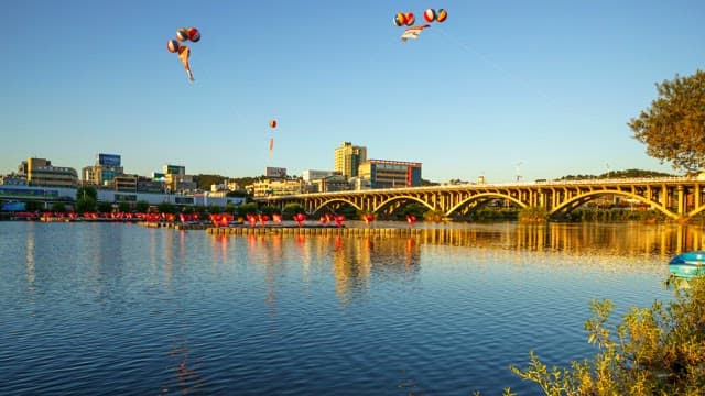 Day to night view of the Jinjugyo Bridge over the river with floating lanterns lit up