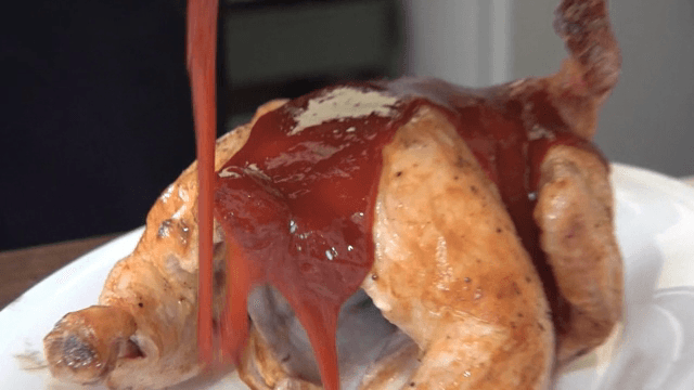 Sauce being poured over roasted chicken