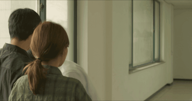 Man leaving after talking with two people in hallway