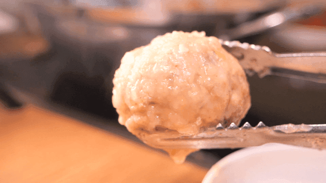 Rolled dumplings held with tongs
