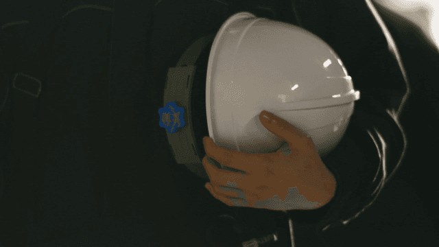 Person holding a white safety helmet