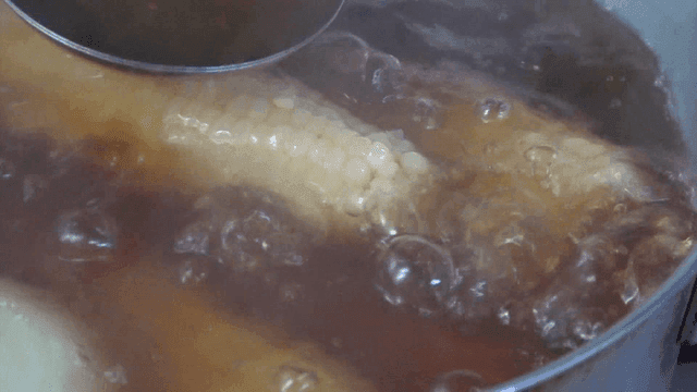 Corn boiling in a pot with broth